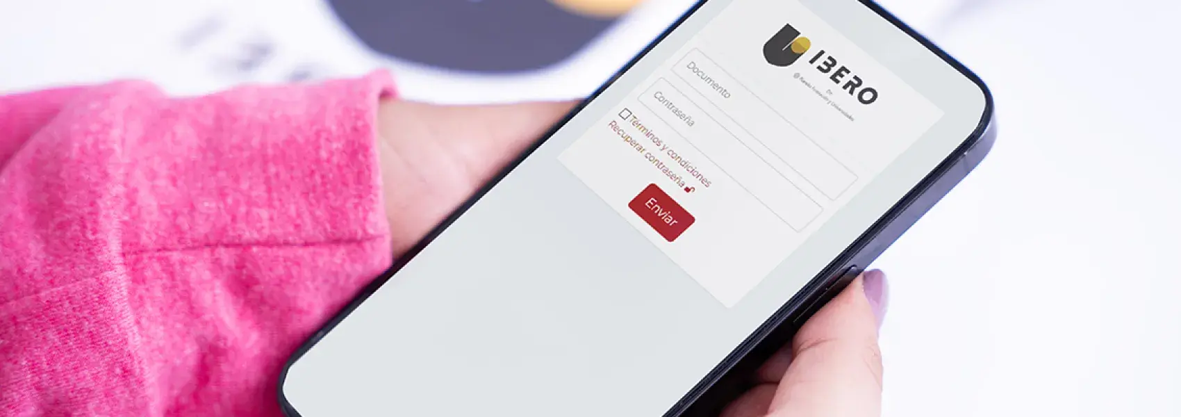 Persona sostiene un celular en la mano, y en la pantalla del dispositivo se visualiza una encuesta.